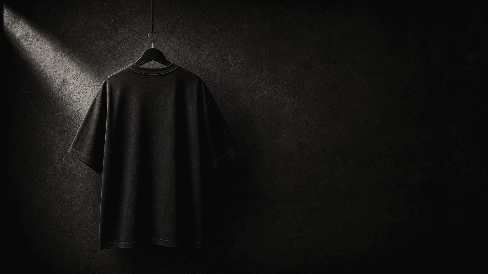 Black INLOOP T-shirt hanging on a studio wall