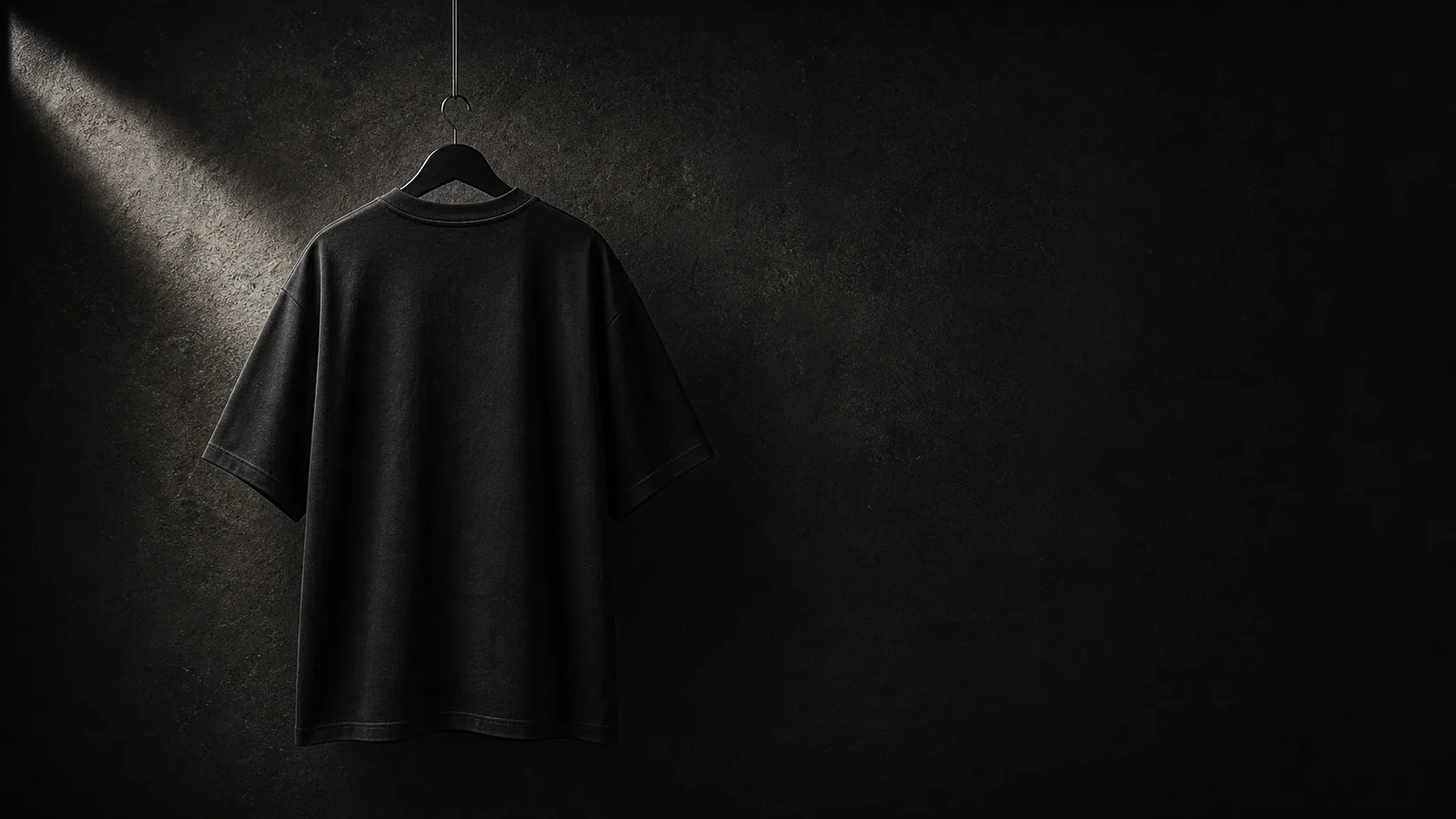 Black INLOOP T-shirt hanging on a studio wall